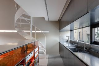 kitchen with staircase up at terada house in Tokyo