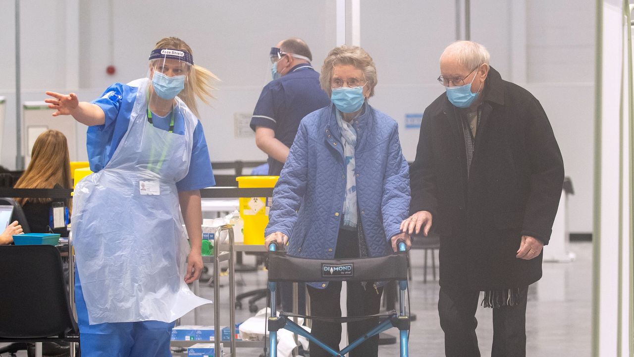 Two elderly people arrive for their Covid vaccinations