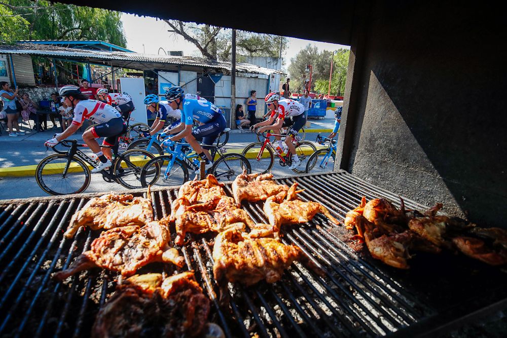 Meat is grilling as the race passes by during stage 1 at the Vuelta a San Juan