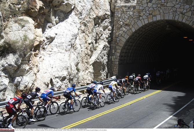 The peloton races through canyon tunnels