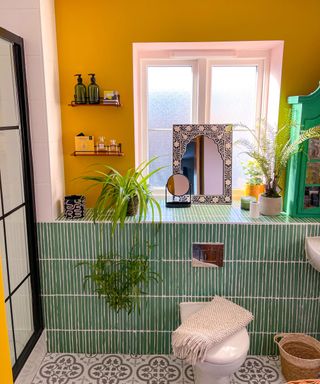 bathroom with yellow walls, painted patterned tiles and patterned floor tiles