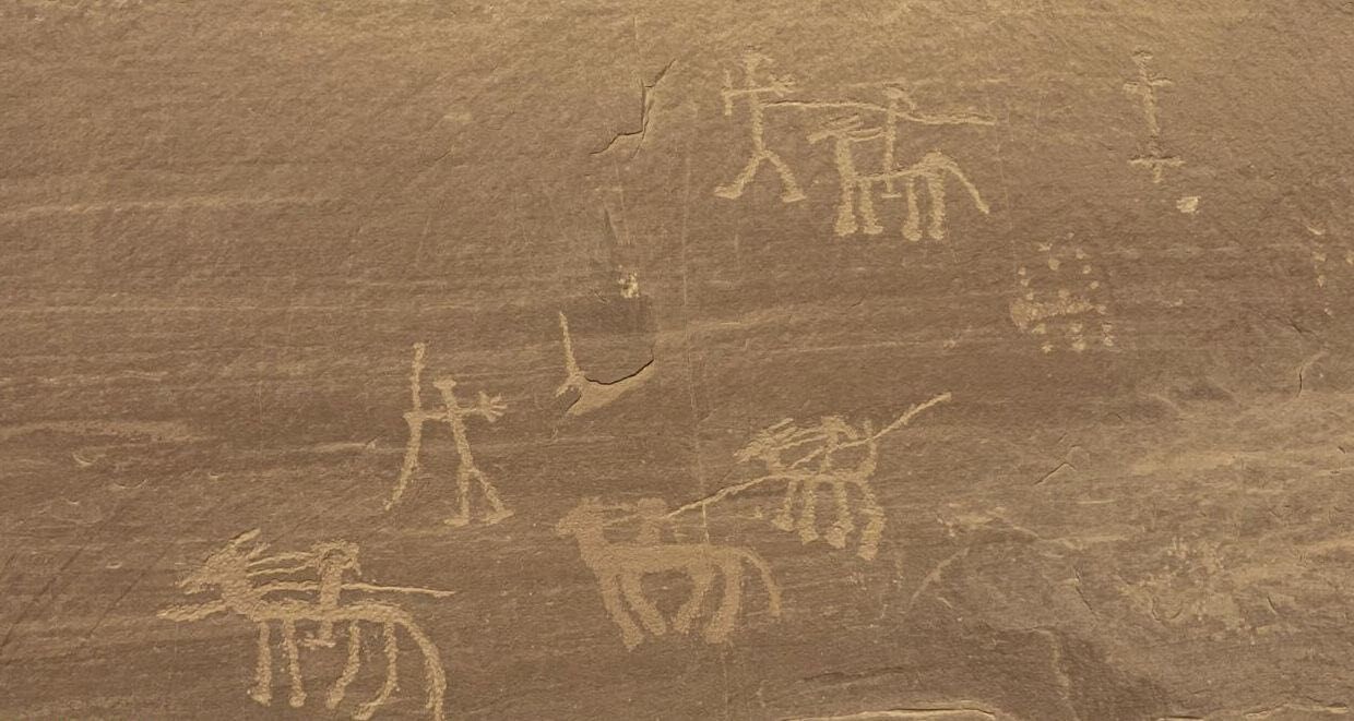 A series of drawings carved into a brown rock face