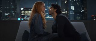 Blake Lively as Lily and Justin Baldoni sitting near each other, looking into each other's eyes with a skyline behind them.