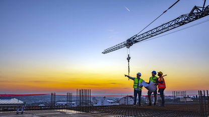 Three people working on construction site