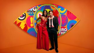 Big Brother 2023 hosts AJ Odudu and Will Best in front of the new show logo