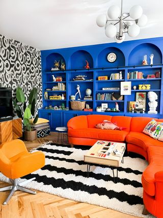 Royal blue is offset by a bright orange curved sofa