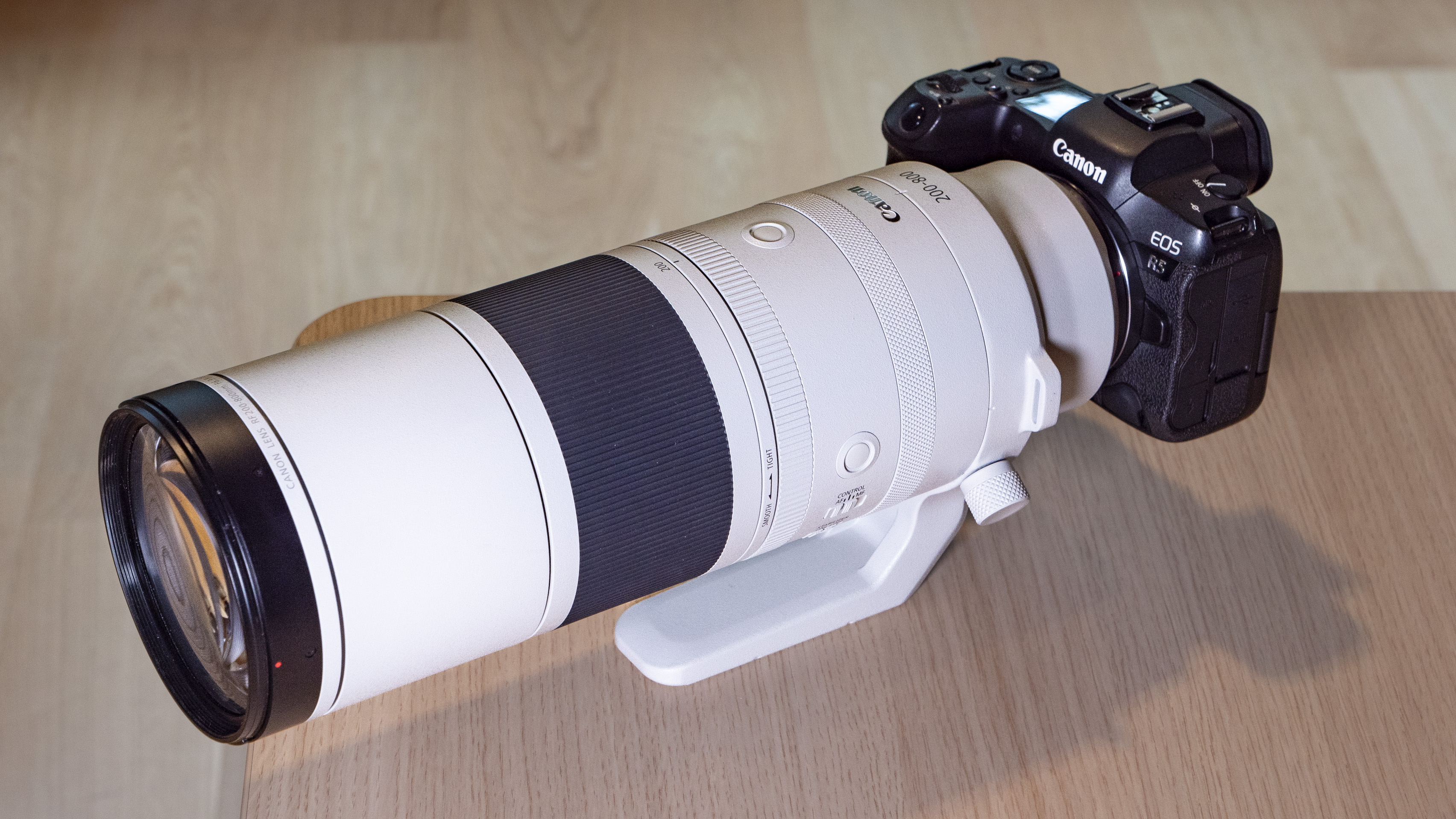 Canon RF 200-800mm F6.3-9 lens on a table, mounted to a Canon EOS R5