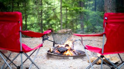 best camping chair: Red camping chairs around an open fire