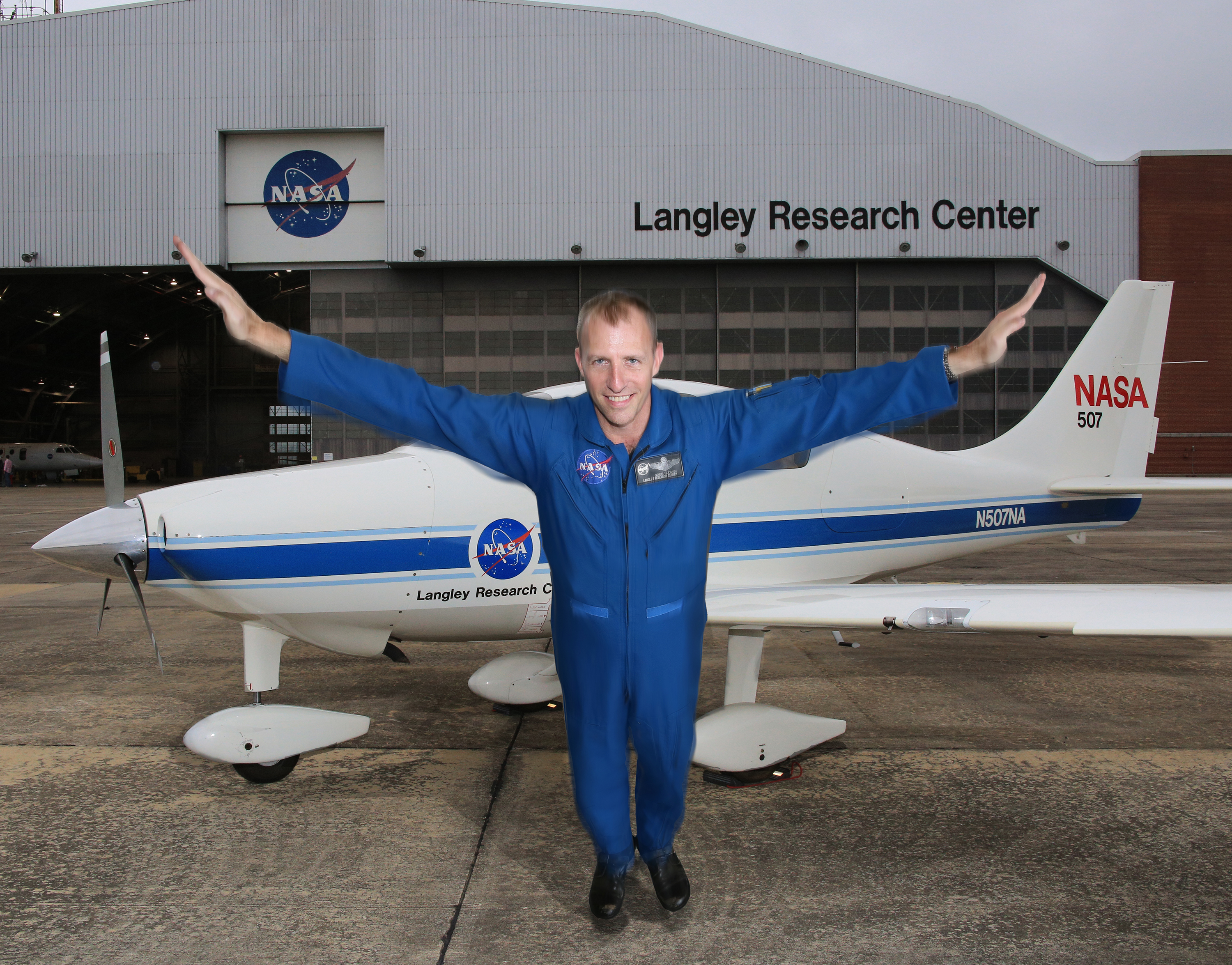 NASA research pilot Greg Slover spreads his arms like wings at the Langley Research Center to celebrate National Aviation Day. 