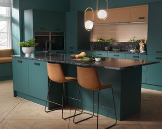 Teal kitchen with bronze features and black granite worktops by Wren