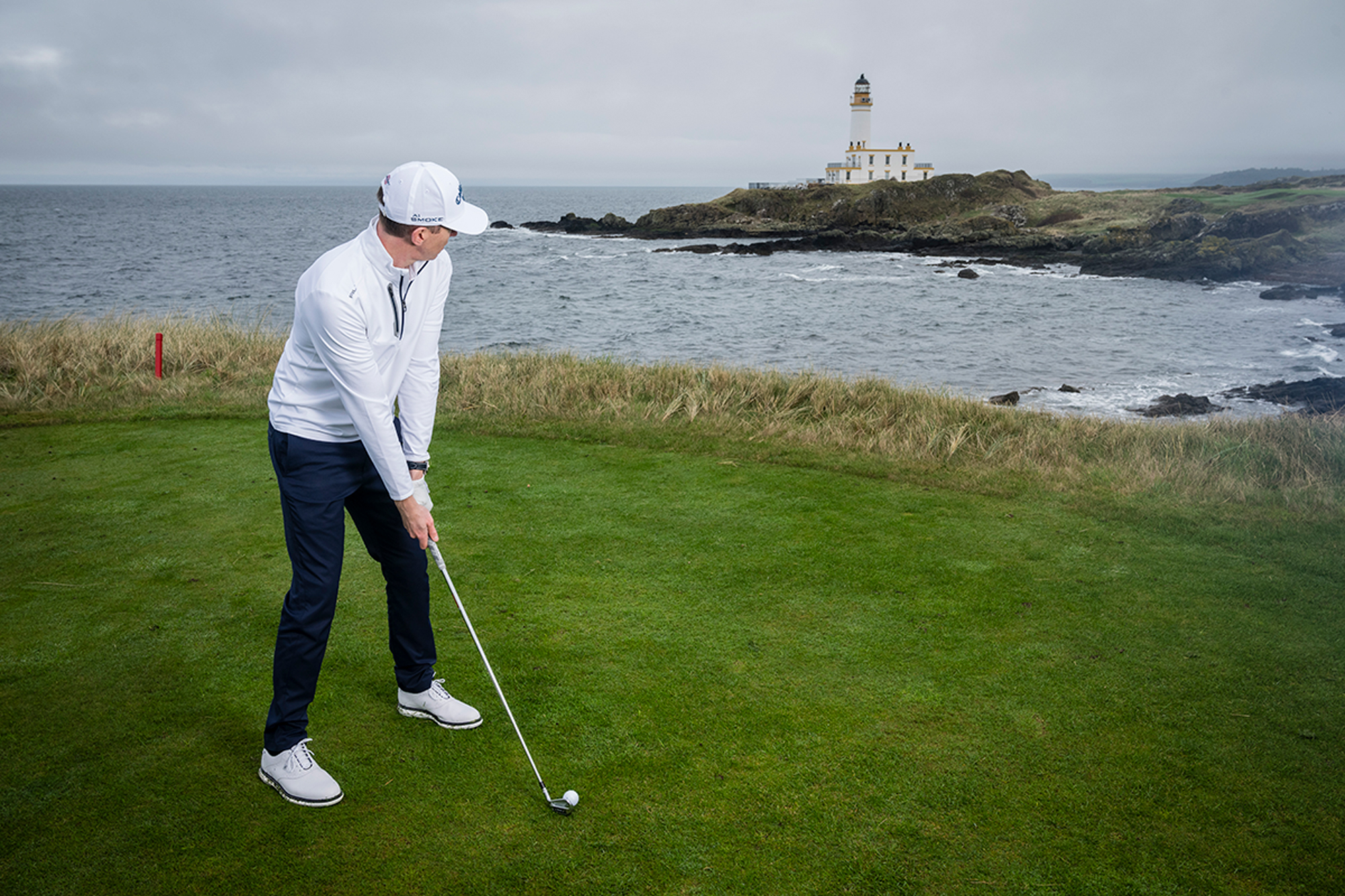 Ben Emerson preparing to hit his tee shot on the par-3 9th tee box at Trump Turnberry, in front of the famous lighthouse