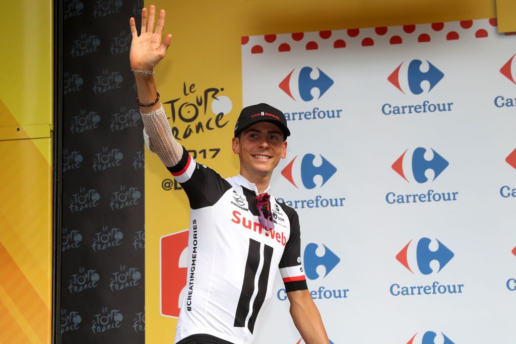 Warren Barguil climbing onto the podium to receive the polka dot jersey after the Tour's 17th stage