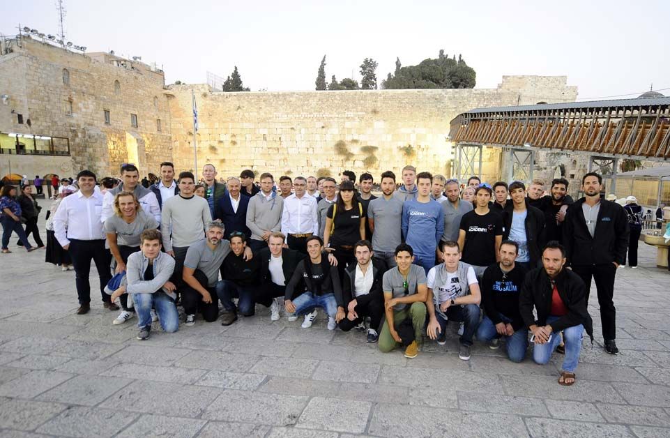 The team poses in front of the Western Wall