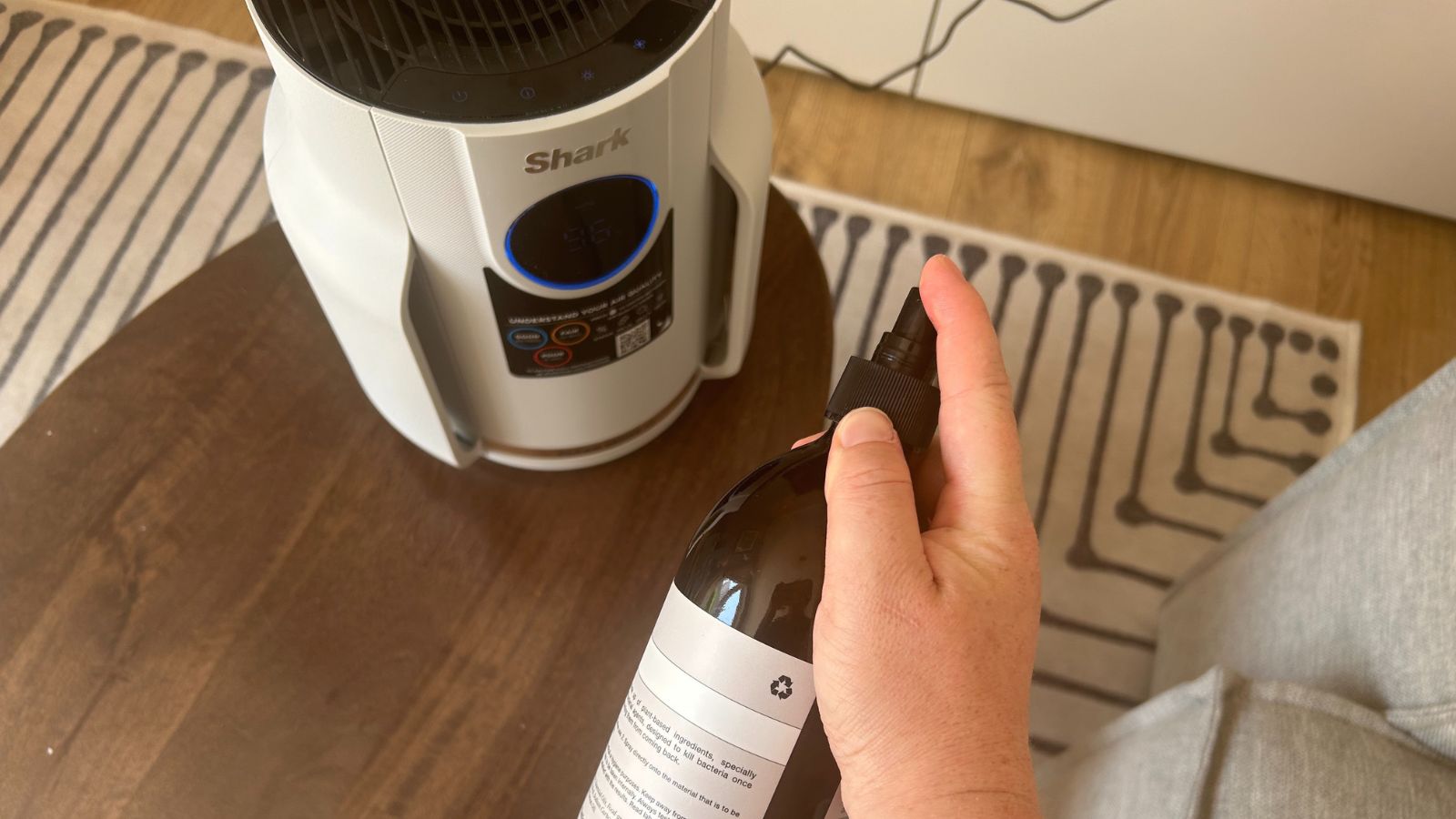 Shark NeverChange Air Purifier Compact Pro on wooden coffee table with spray