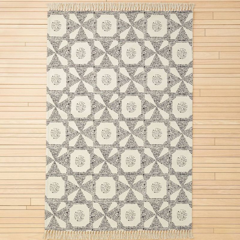 A cream and black printed area rug that