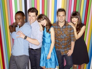 a promo shot for new girl of the cast posing together in front of a colorful wall