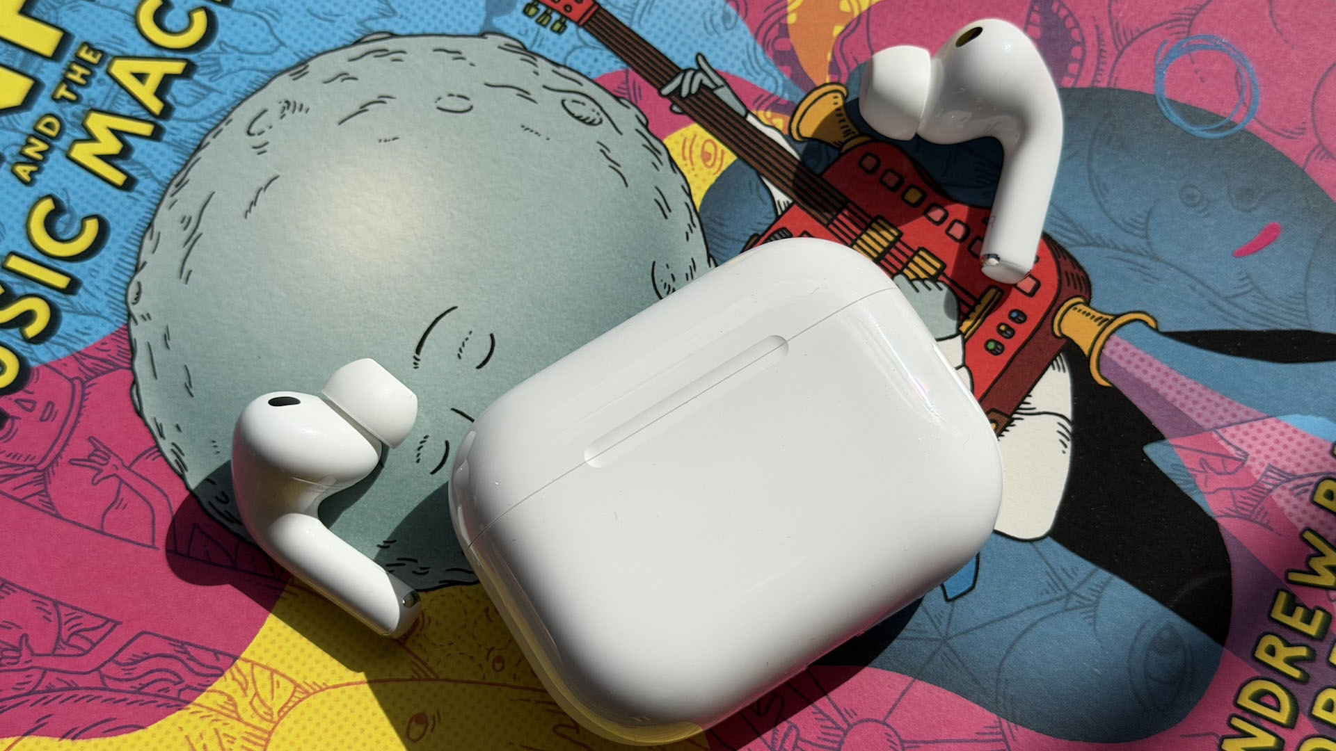 The AirPods Pro 3 earbuds from Apple against the pages of a graphic novel.