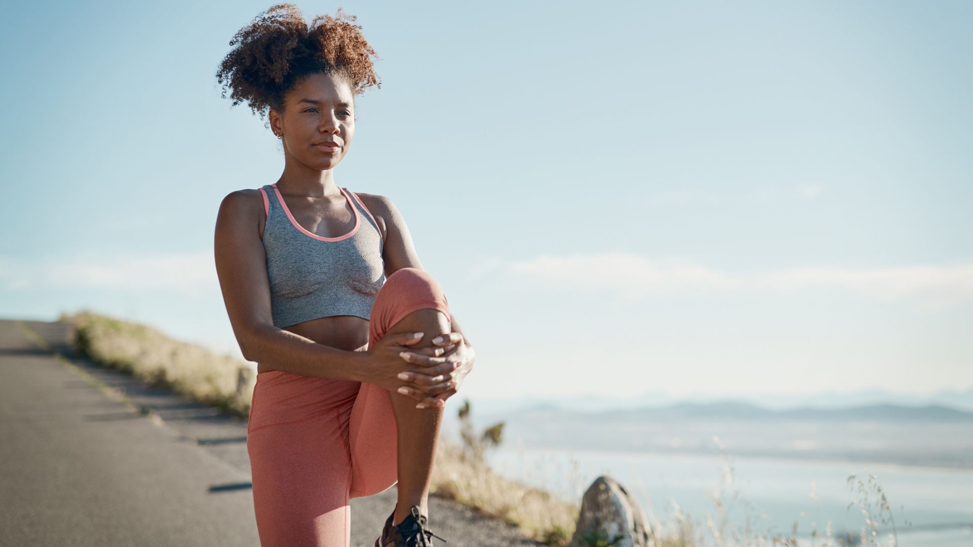 woman stretches mid run