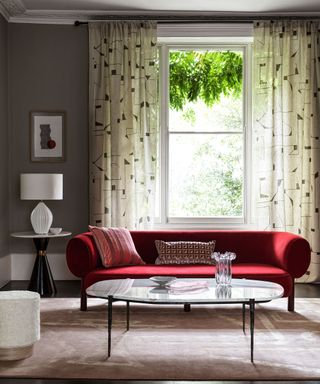 monochrome living room with vibrant red velvet sofa and geometric design curtain fabric