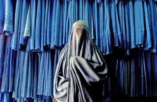 someone with a veil on in front of a blue background