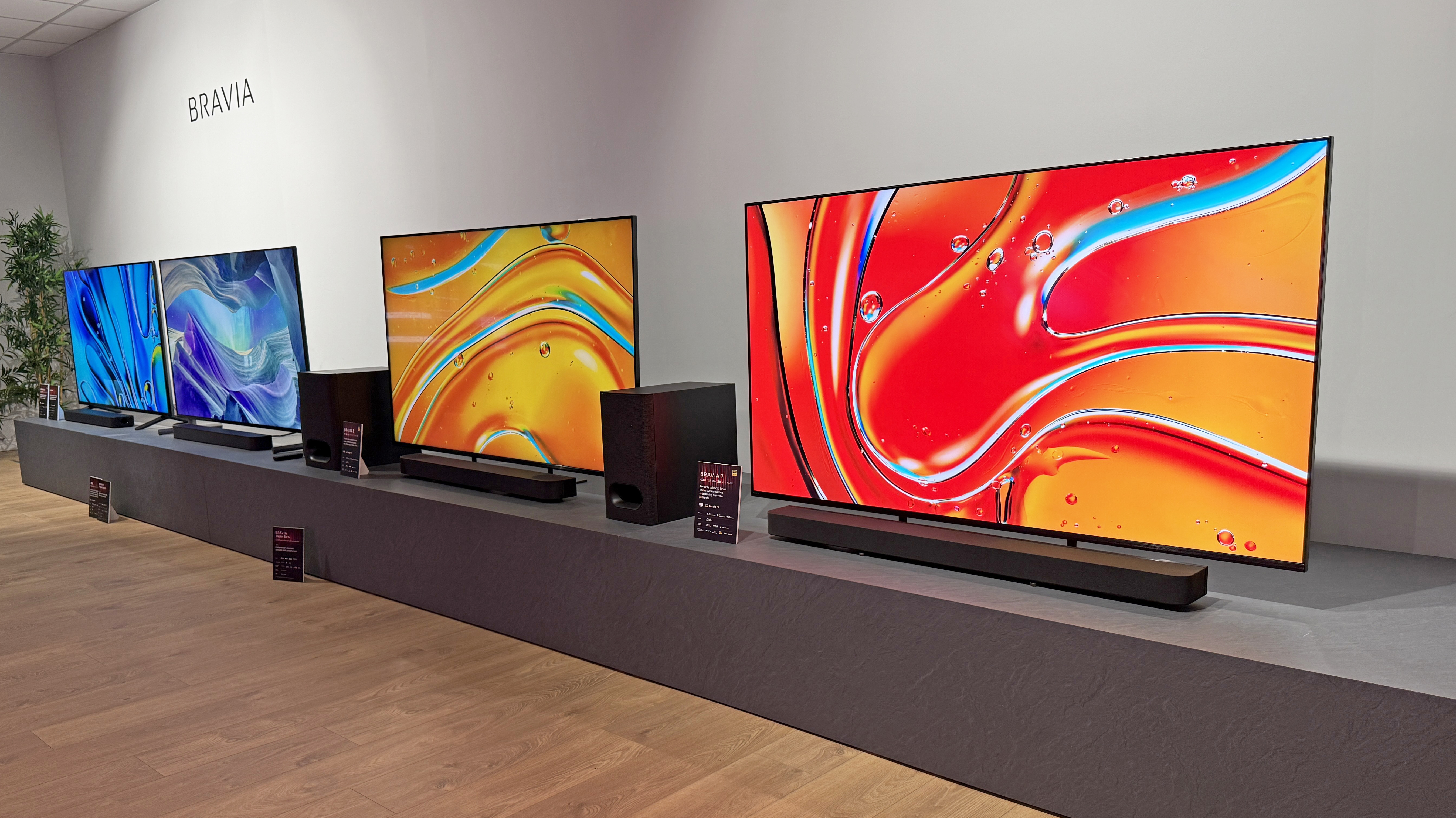 Sony TVs next to each other on a very long bench
