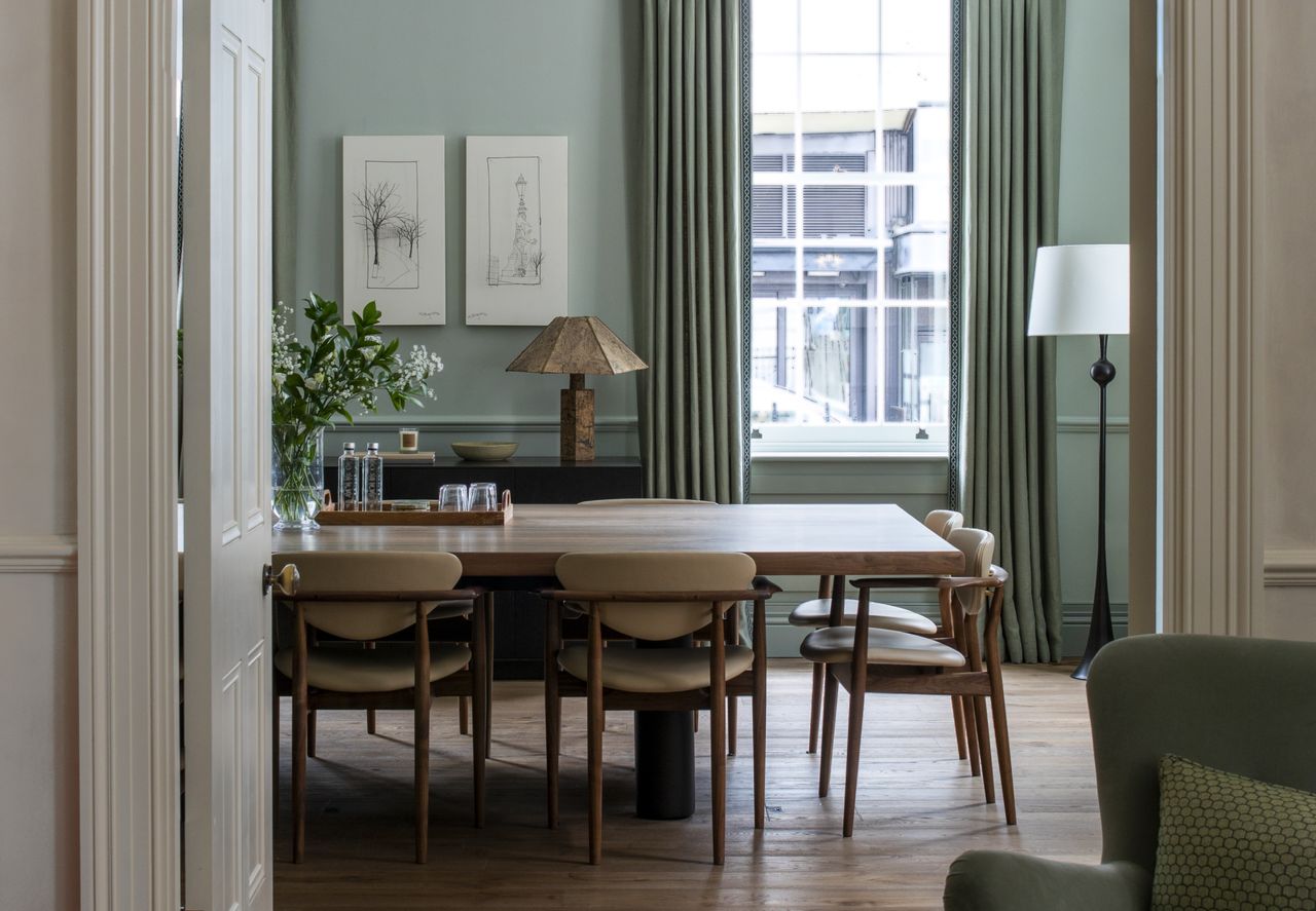 A pale blue dining room with wooden dining set