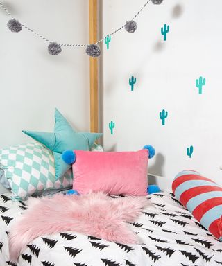 Kids' bedroom idea with velvet cushions and pompom garland