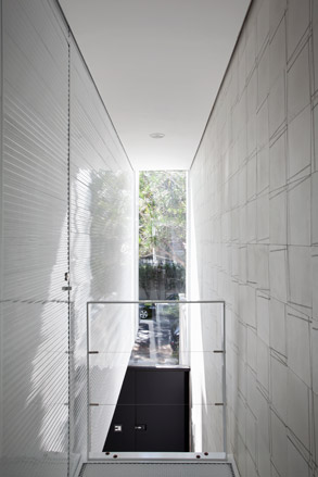 A landing, lit by a large opening in the facade of the house