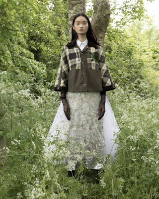 Model in tartan wax cape