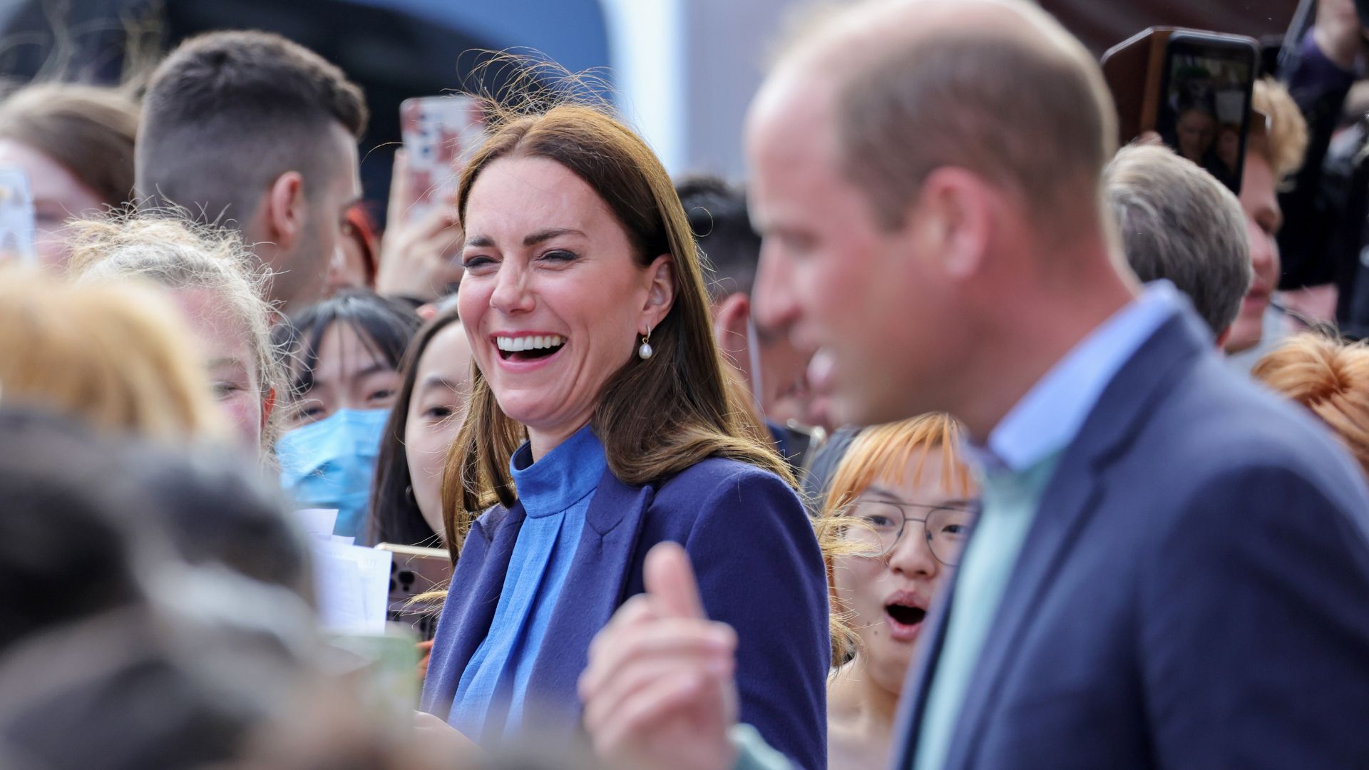 Prince William gestures towards Kate Middleton as they greet fans