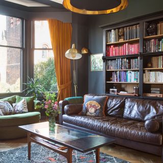 Living room with teal walls, large leather sofa and bookshelf