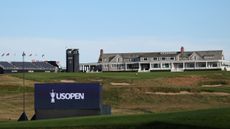 Looking up towards the Shinnecock Hills golf clubhouse with a navy blue US Open sign in view