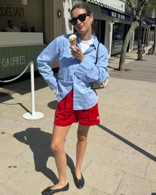 Woman in track shorts and button-down.