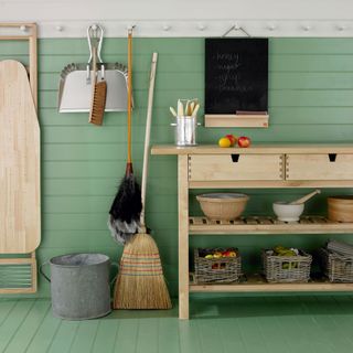 green utility room with peg rail hang an ironing board chalkboard dustpan and brush and duster