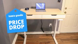 A RealSpace standing desk in a home office with a price drop badge