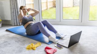 Which exercise burns the most calories? Image shows woman doing sit up at home