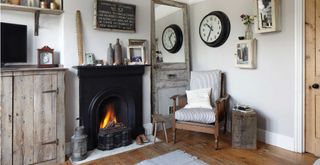 grey living room with an open fire with chair beside and vintage accesories to suppurt tips fro buying second hand furniture
