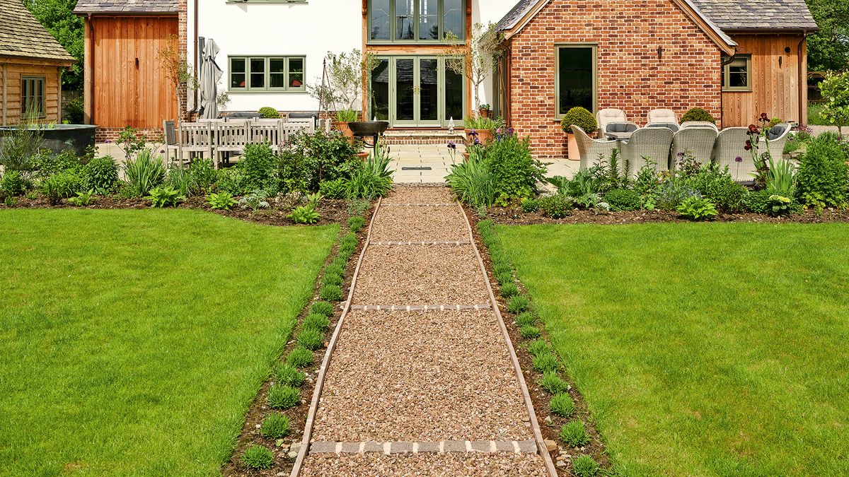 The lawn at the front of a house with a straight gravel path running through the middle