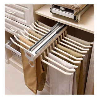 A pull out pants rack with trousers draped on the rungs
