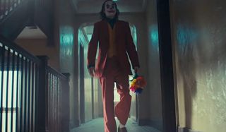 Joker walks down the hallway with fake flowers in hand