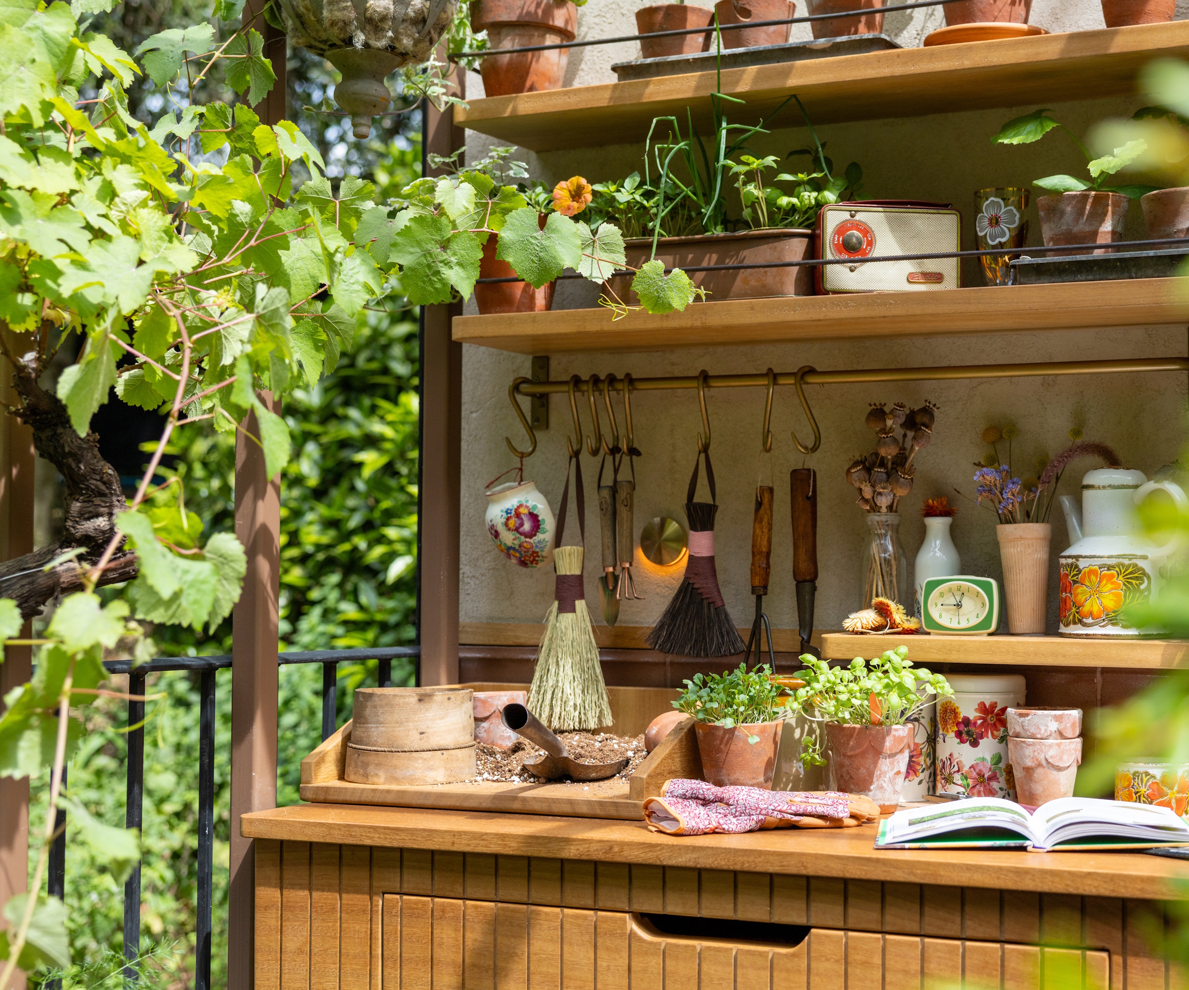 Retro-inspired potting shed shelves with terracotta pots and gardening tools, vintage pots and china