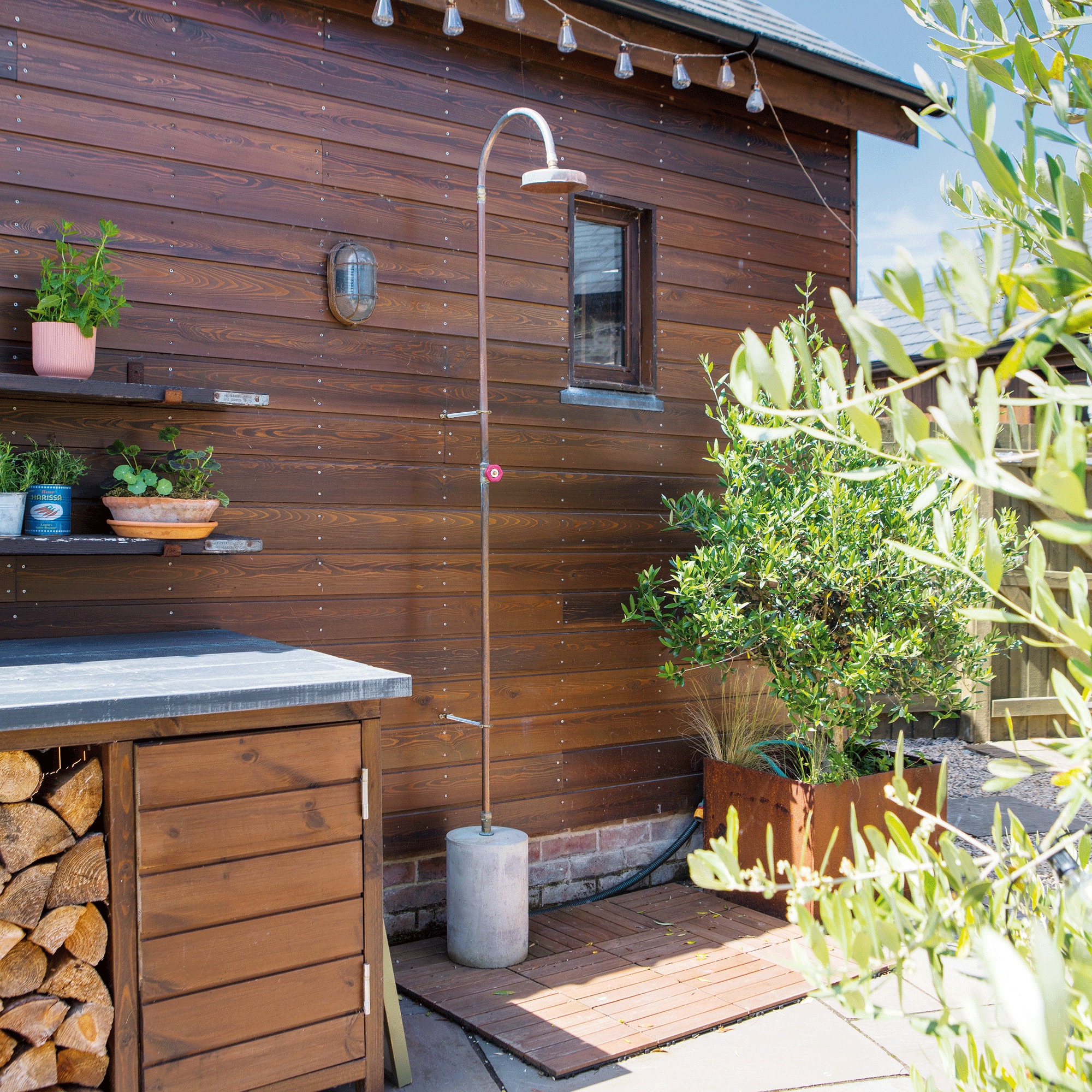 the side of a wooden clad building with an outdoor shower