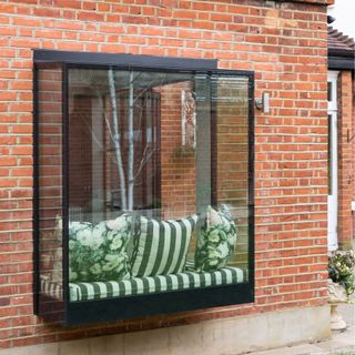 Orell window with striped cushion in from the outside view