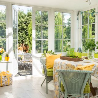 Interior of conservatory with table and green rattan chairs