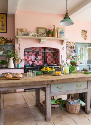 table and aga in colourful unfitted kitchen in Jacobean manor house