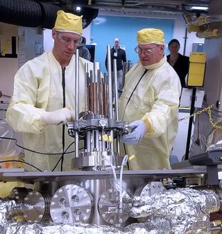 Marc Gibson, Kilopower lead engineer at NASA's Glenn Research Center, and Jim Sanzi of Vantage Partners install equipment on KRUSTY (Kilopower Reactor Using Stirling Technology) at the Nevada National Security Site (NNSS).