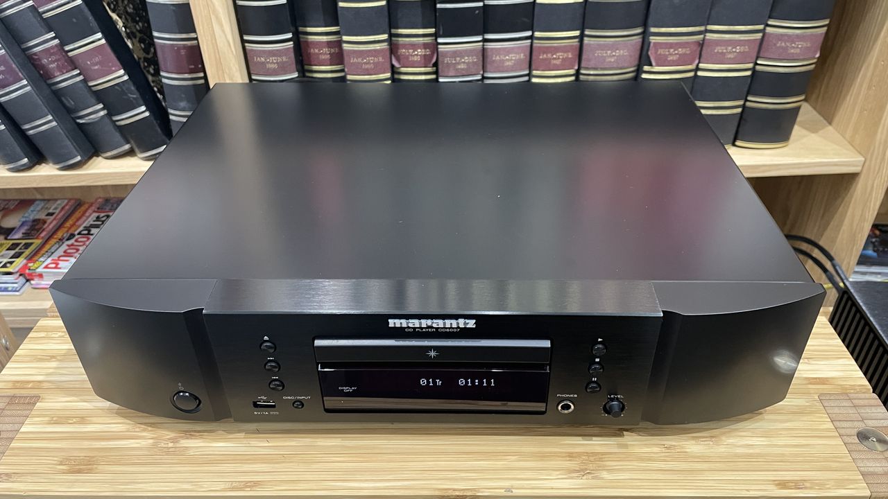 Top down image of Marantz CD6007 on wooden rack with magazines in background