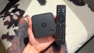 The Vodafone TV box and remote being held in the hand