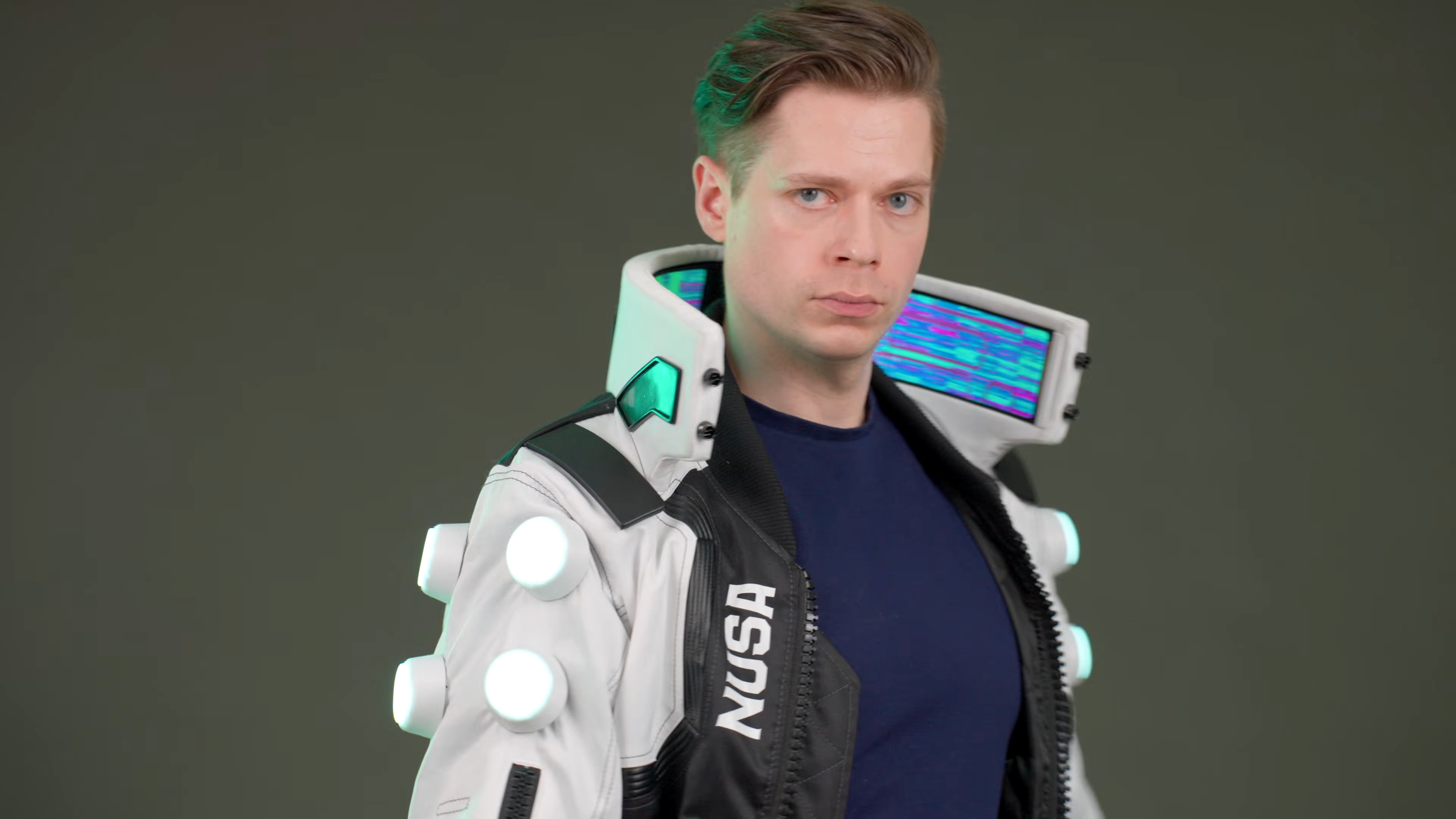 Cosplayer and hardware creator Zibartas models hand-made Cyberpunk 2077 bomber jacket. The garment features a tall standing collar with flexible OLED screens housed inside it.