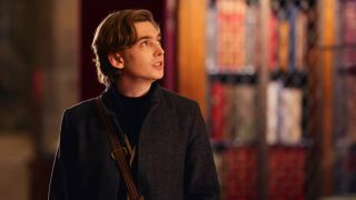 Austin Abrams looking at books in Dash and Lily.